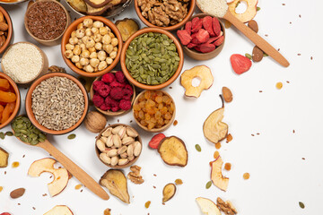 Healthy vegetarian food concept. Assortment of dried fruits, nuts and seeds on white background. Top view. Mixed nuts set closeup.