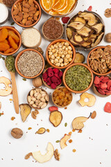 Healthy vegetarian food concept. Assortment of dried fruits, nuts and seeds on white background. Top view. Mixed nuts set closeup.