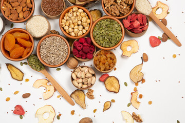 Healthy vegetarian food concept. Assortment of dried fruits, nuts and seeds on white background. Top view. Mixed nuts set closeup.