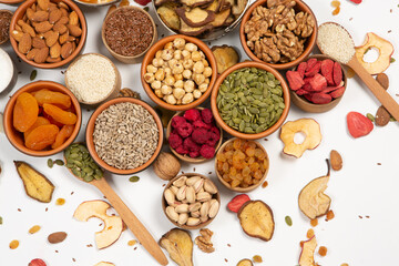 Healthy vegetarian food concept. Assortment of dried fruits, nuts and seeds on white background. Top view. Mixed nuts set closeup.
