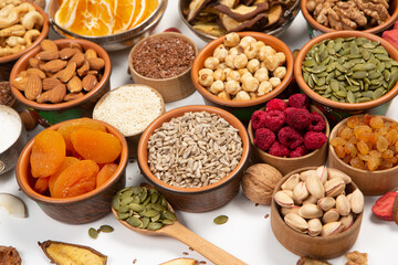 Healthy vegetarian food concept. Assortment of dried fruits, nuts and seeds on white background. Top view.