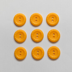 Set of yellow plastic buttons on a white background. Sewing tools. Top view.