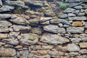 Old solid stone wall, weathered worn wallpaper texture