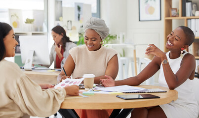 Diverse group of smiling business women planning a brainstorm meeting in office. Happy confident professional team sitting together and using paperwork, talking and cooperation on marketing strategy