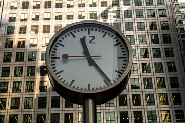 Fototapeta na wymiar Canary Wharf Clocks against glass and steel buildings