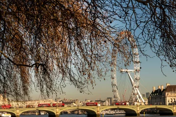 Poster red buses crossing the river Thames with trees and blue sky © Aitcheeboy