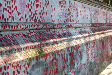Painted red hearts on a memorial wall to coved victims
