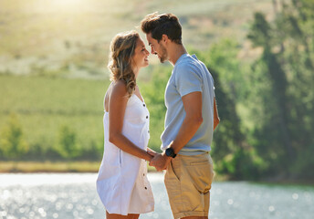 Couple holding hands, relax by lake and summer, travel and adventure with love and care outdoor. People in relationship, trust and bonding on vacation, man and woman with happiness and freedom