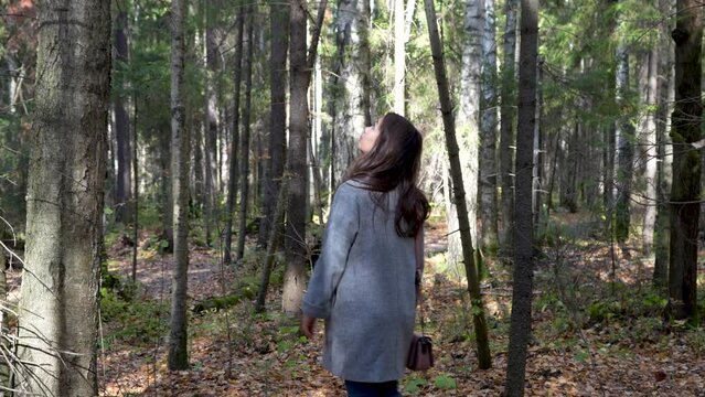 Young woman enjoying autumn forest.