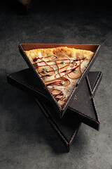 Take away box with a slice of giant pear and gorgonzola pizza