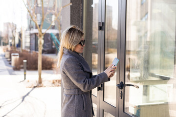 Woman hands using phone scan to digital door lock security systems at home.