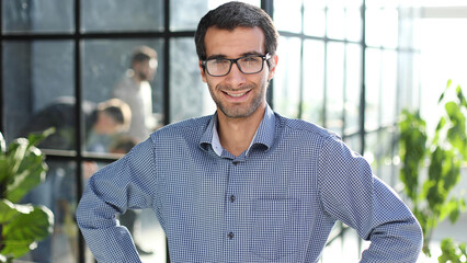 Young businessman in casual clothes stands with his hands on his waist