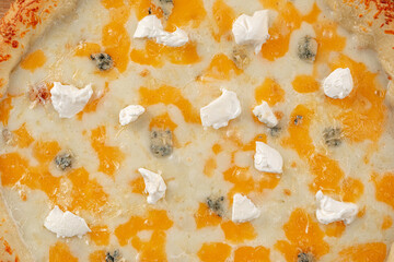 Closeup on four cheese pizza with cheddar and gorgonzola