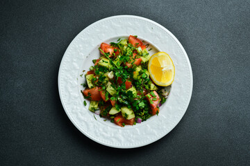 Fresh vegetable salad with olive oil and lemon. In a white plate. Free space for text.