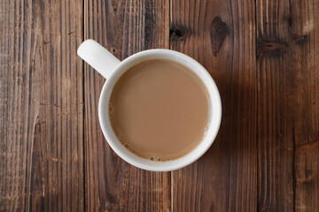 Cup of coffee on rustic wood. Overhead view.