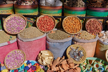 Moroccan beauty items, soaps, clay massagers and flowers in bags at a market in the souks of Marrakech, Morocco.