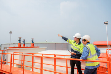 2 Asian male industrial engineers and architects Work to inspect water systems and water tank...