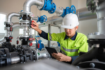 A male industrial engineer Controlling the operation of water pipes and water systems in engineering plants. Utilities Water storage pipes and wastewater treatment plants