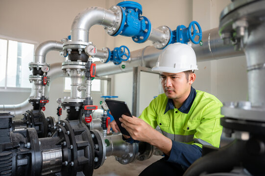 Asian industrial engineers work to inspect and maintain factory pipes or water systems in engineering plants, utilities, sewers and industrial wastewater treatment plants.