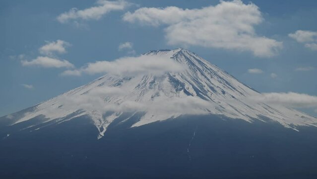 Aerial close up  view of peaceful Mount Fuji with beautiful white clouds above the clear blue sky. Japan
