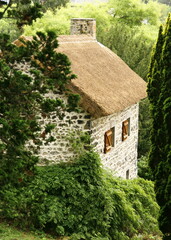 Fototapeta na wymiar Une chaumière avec le toit en chaume, typique de Murol, dans la région d'Auvergne, dans le département du Puy-de-Dôme en France