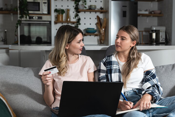 Two Happy Ladies Using Laptop Computer Working And Learning Online Together Or Making Video Call Sitting At Desk In Modern Home Office. E-Learning. Females Entrepreneurship Career Concept
