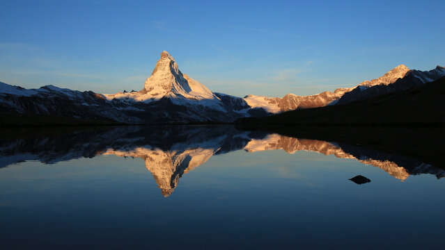 Snow capped Mount Matterhorn mirroring in Lake Stellisee.