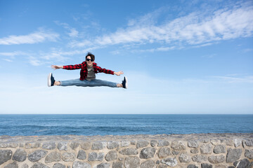 Teenager boy jumping at coast