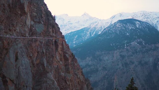 Road of Kalpa with dangerous trench known as Kalpa Suicide point. Suicide point is situated on the road linking Roghi with Kalpa in Himachal Pradesh, India. Road with views of snow covered mountains.