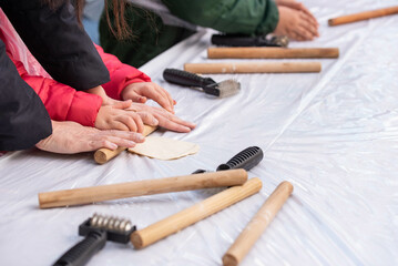 Kids cooking, roll out the dough and making matzah for Jewish holiday Passover Pesach at culinary master class for children outdoor in park. 