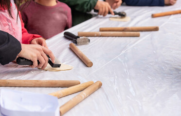 Kids cooking, roll out the dough and making matzah for Jewish holiday Passover Pesach at culinary master class for children outdoor in park. 