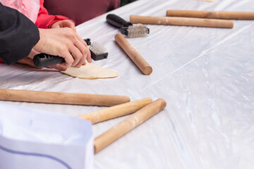 Kids cooking, roll out the dough and making matzah for Jewish holiday Passover Pesach at culinary master class for children outdoor in park. 