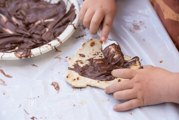 Kids cooking, roll out the dough and making matzah for Jewish holiday Passover Pesach at culinary master class for children outdoor in park. 