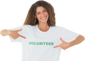 Smiling volunteer pointing to her tshirt looking at camera