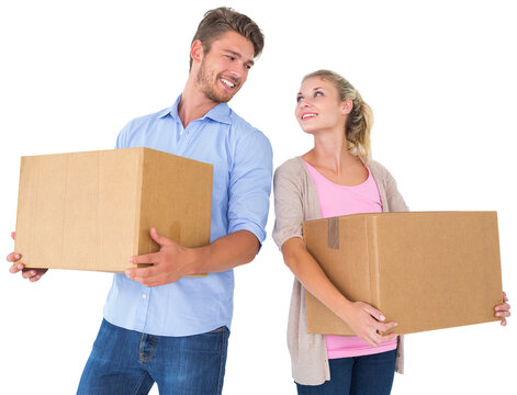 Attractive young couple carrying moving boxes