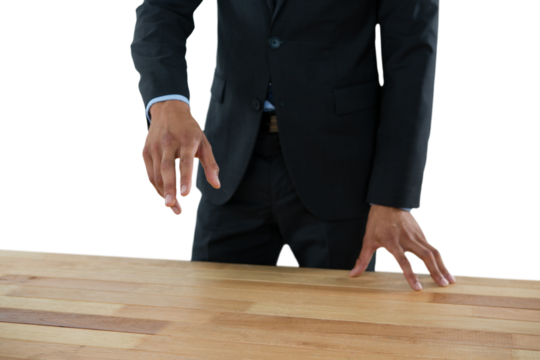 Mid section of businessman gesturing while standing at table