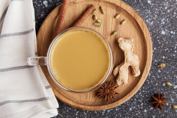 Indian masala tea. Traditional Indian hot drink with milk and spices on a wooden background close-up