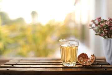 Bael tea in a glass cup on wooden tray