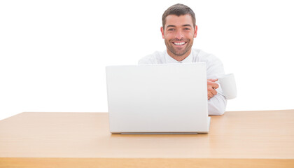 Smiling businessman with coffee cup sitting at desk