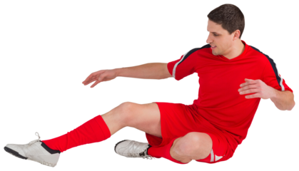 Fit football player jumping and kicking
