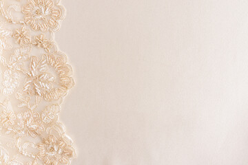 Chic satin beige background with floral lace on the left side. a copy of the space. wedding photo...