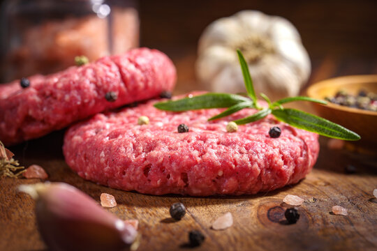 Stek z mięsa mielonego do hamburgera z przyprawami, cebula, papryka na starych deskach