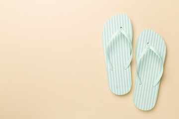 Striped flip flops on color background, top view