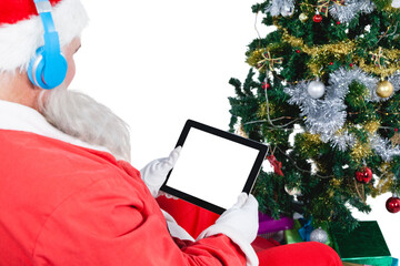 Santa Claus listening music and using digital tablet 