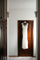 abito da sposa appeso sulla porta di una stanza