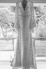 foto in bianco e nero di un abito da sposa appeso