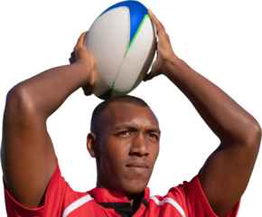 Rugby player holding football above head.