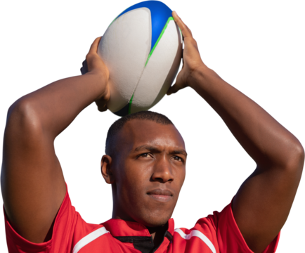Rugby player holding football above head.