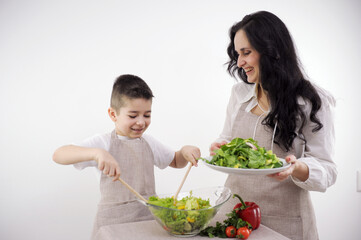 family, cooking and people concept happy mother and little son with molds making cookies from dough on a white background