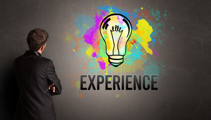 businessman drawing colorful light bulb